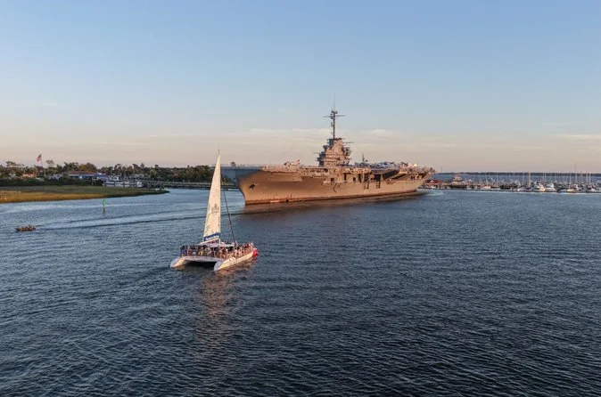 Ein Katamaran segelt im Hafen von Charleston an dem Flugzeugträger USS Yorktown vorbei